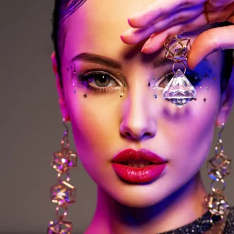 Portrait of beautiful young woman with bright makeup. Shiny sequ
