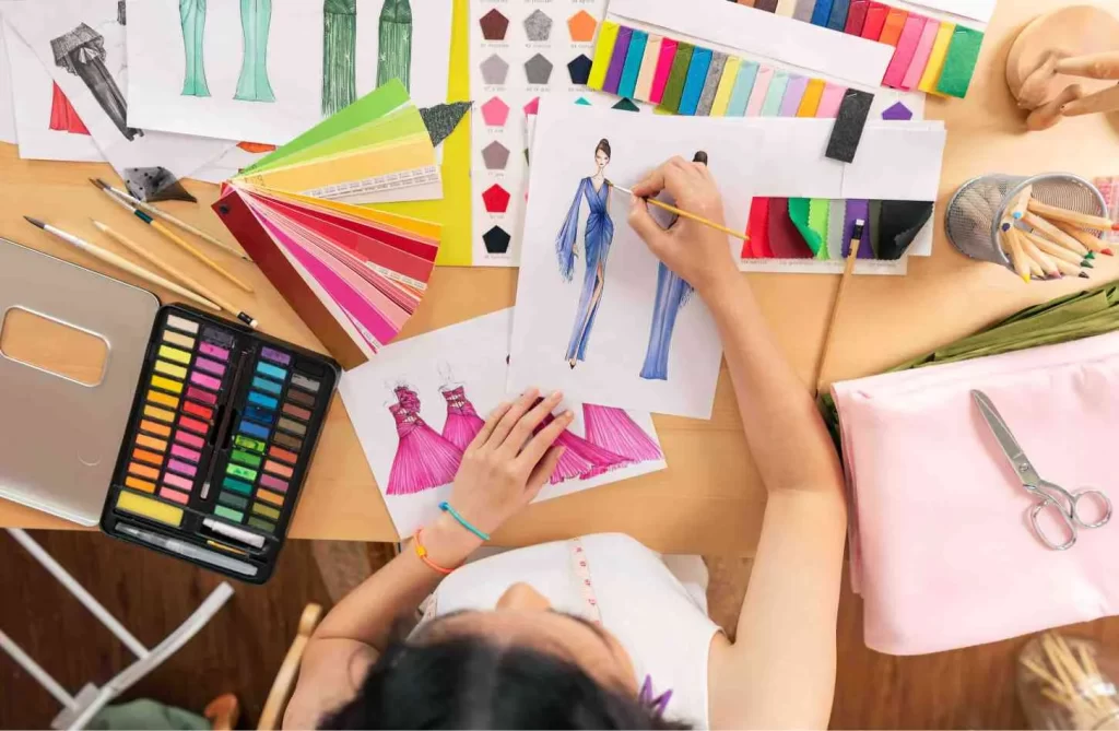 asian-fashion-designer-drawing-sketches-new-collection-desk-office-top-view Fashion designing courses after 12th
